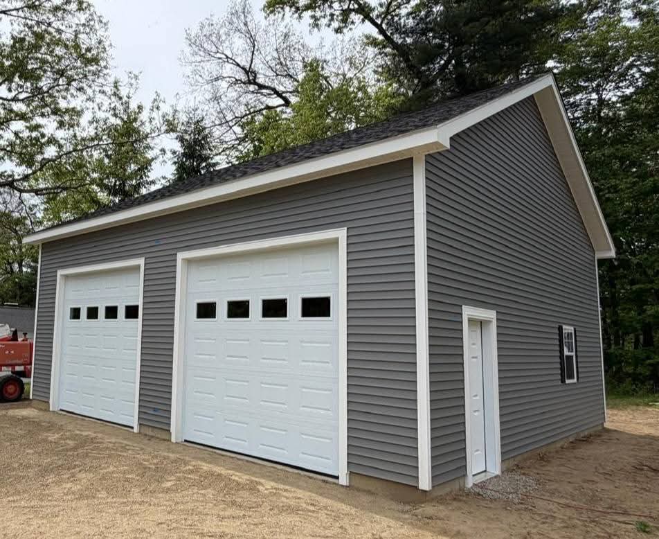 Single-level garage with two white overhead doors on the eave side