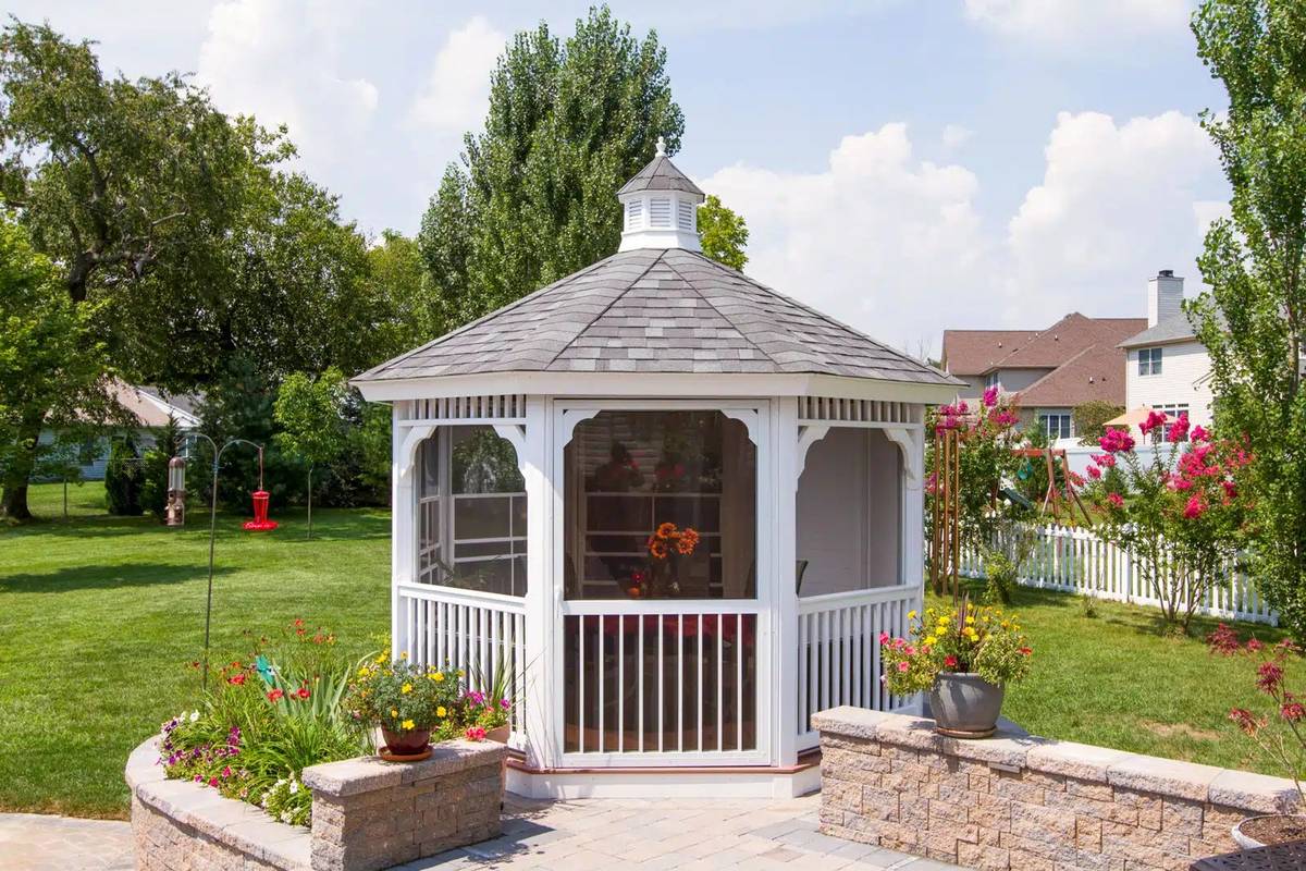 White vinyl octagon gazebo in a backyard garden